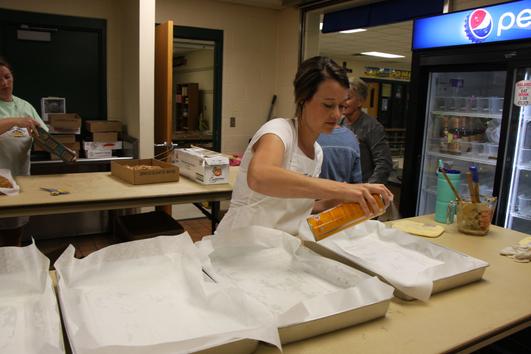 Gia Zarek sprays the pans